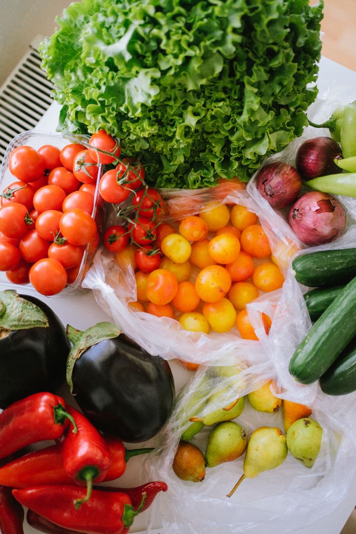 A vibrant assortment of fresh vegetables including tomatoes, peppers, cucumbers, and lettuce displayed on a table.