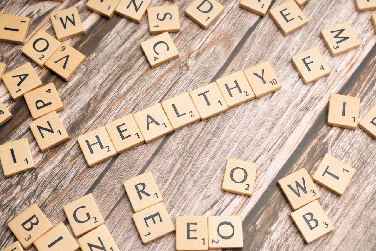 services-01 Wooden letter tiles arranged on a wooden surface spelling out 'healthy', symbolizing wellness.
